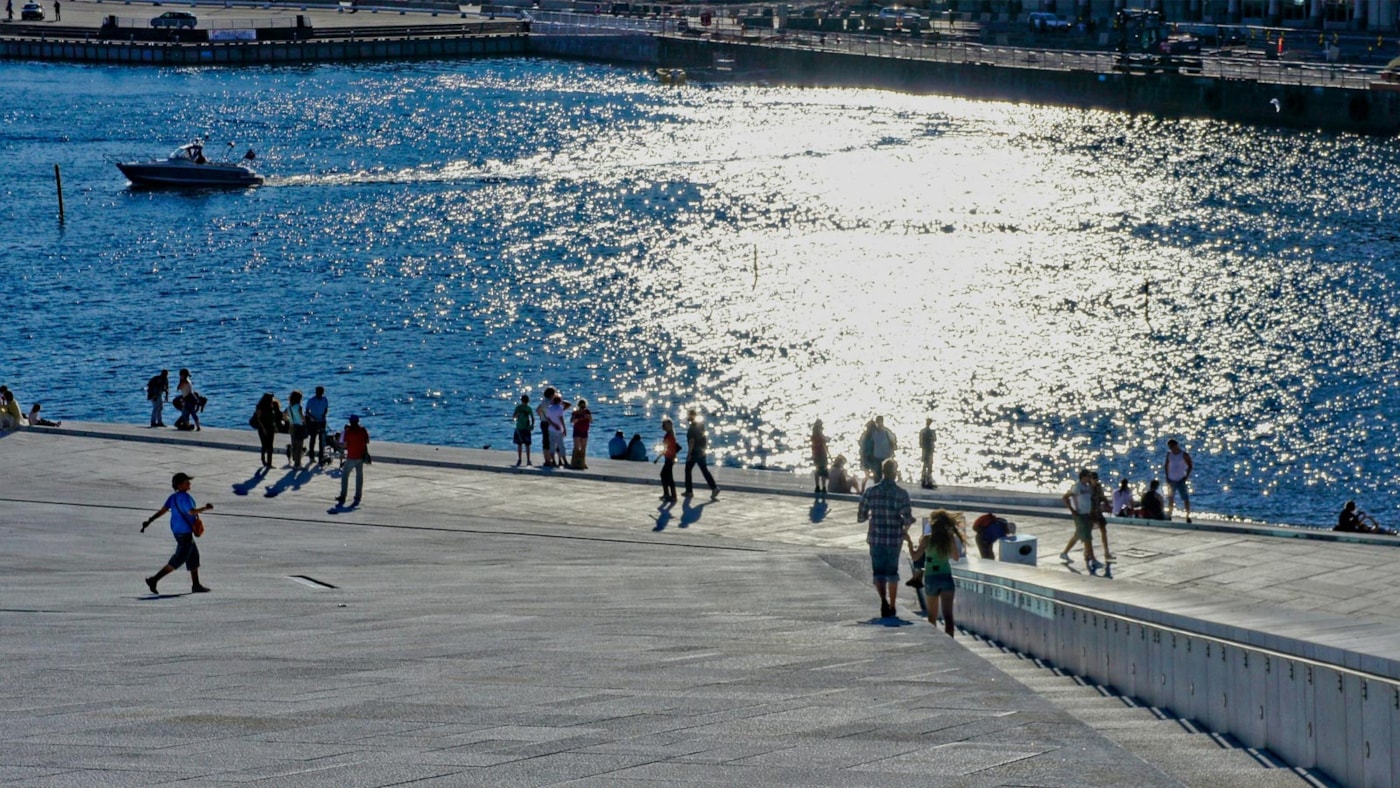 Mennesker i sommersol ved Operaen i Oslo