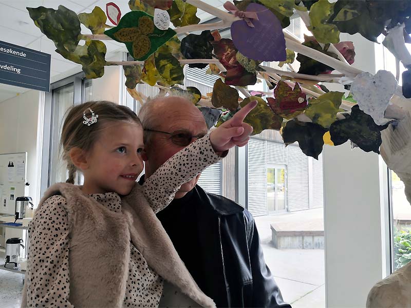 Frida og bestefaren under skulpturen Nytt Liv